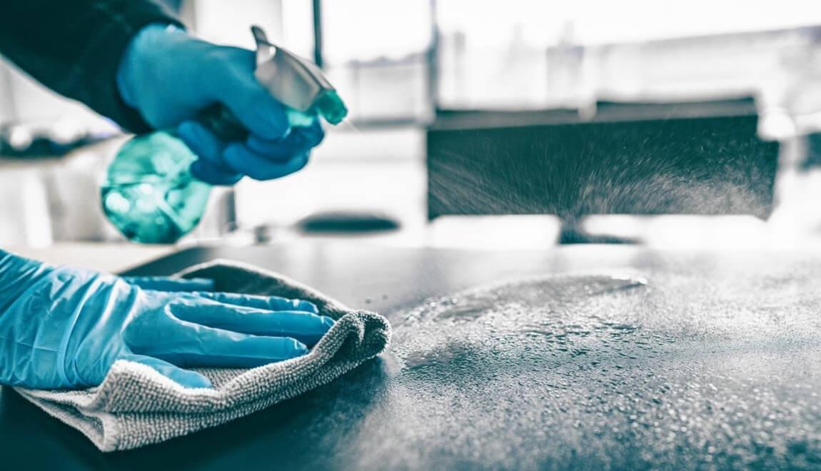 blue rubber gloves spray cleaning solution on a countertop 