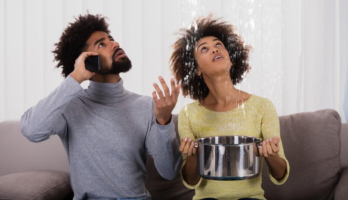 Couple catching water from the ceiling