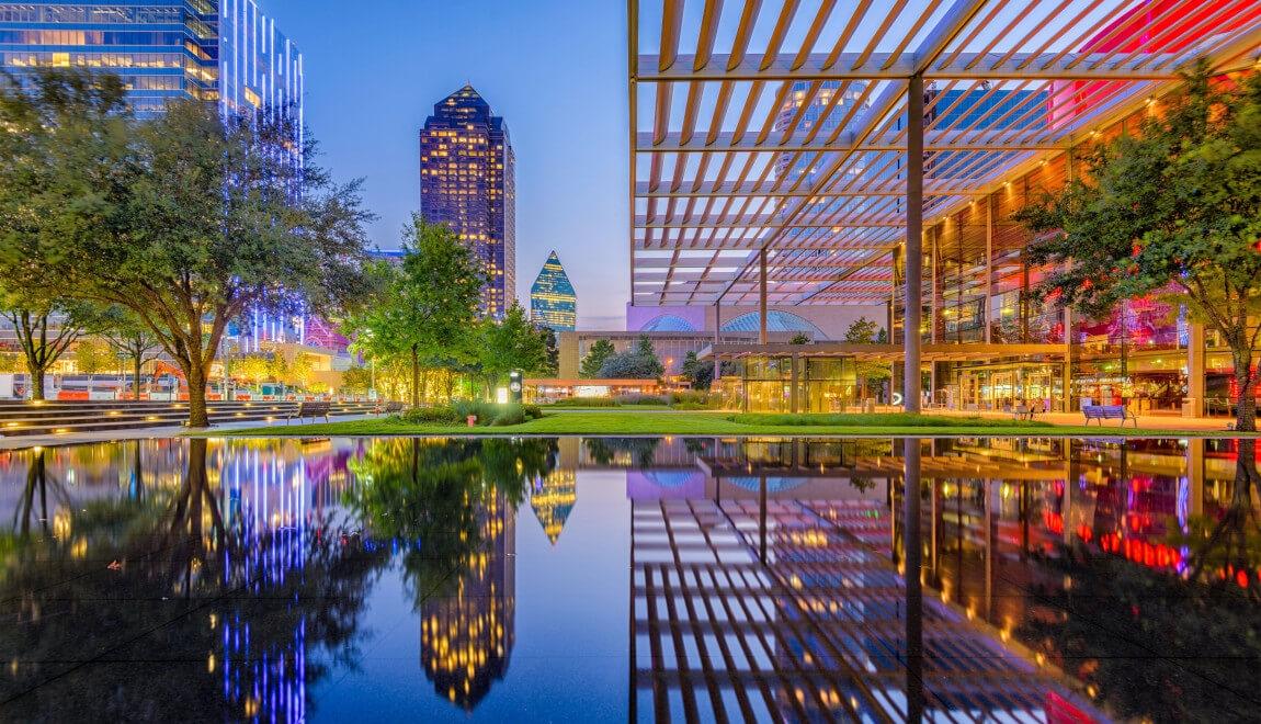 A covered walkway in Dallas, TX at dusk.