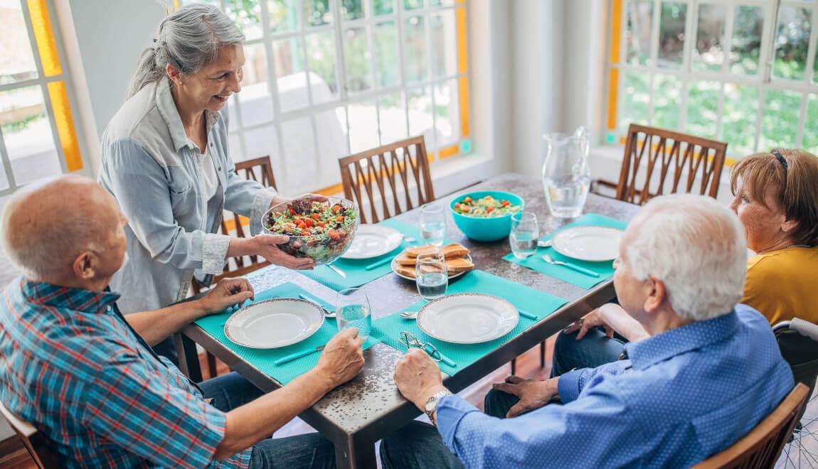 Two older couples sitting around a dinner table.