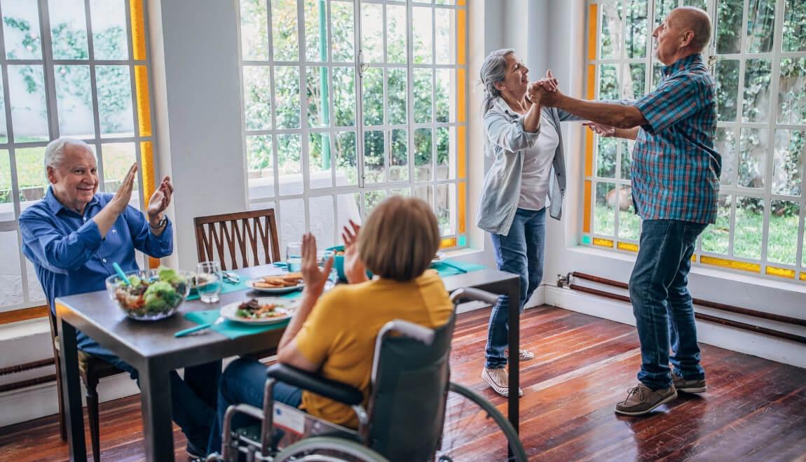 Two senior couples dance after dinner. 