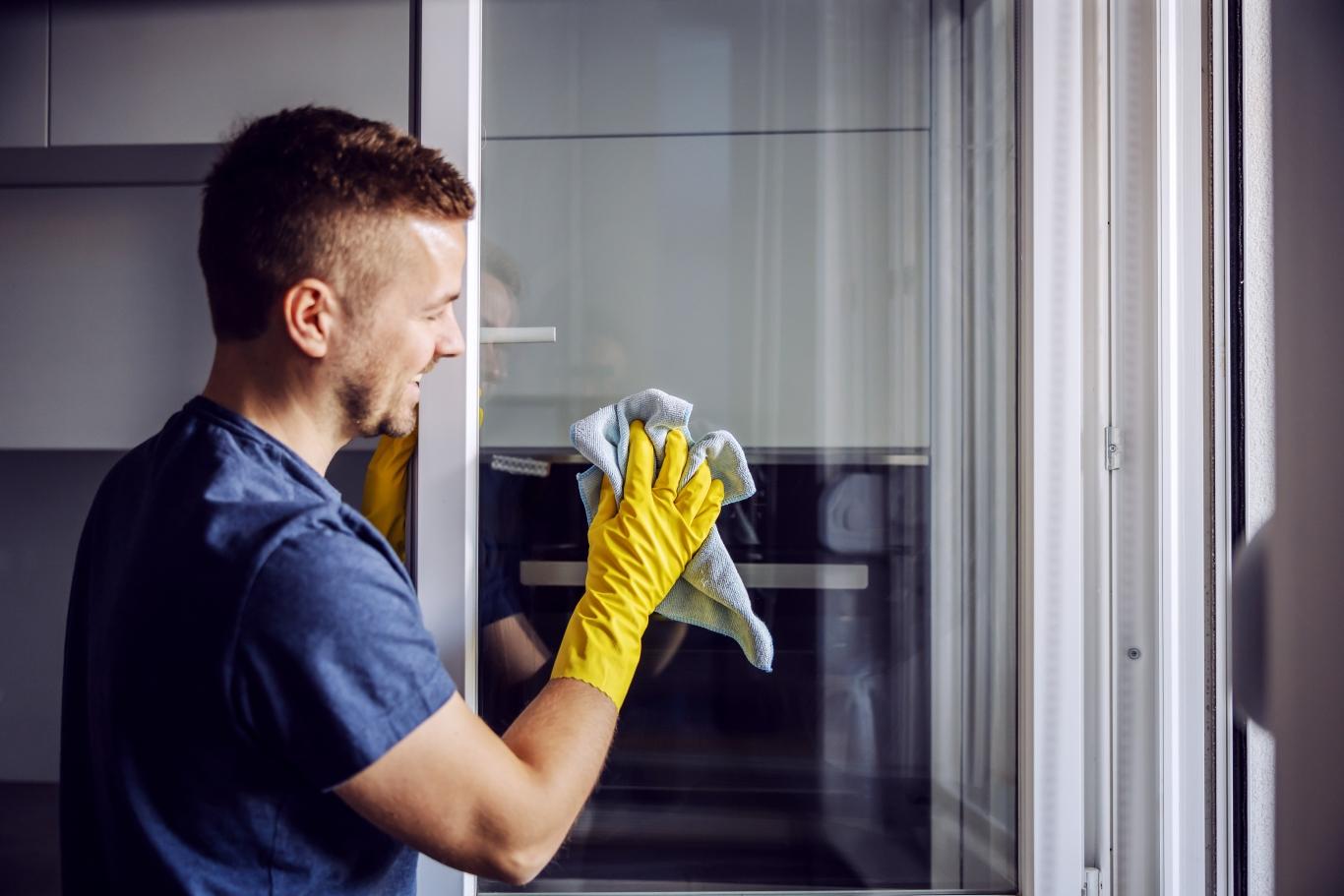 A picture of a man cleaning a window. 