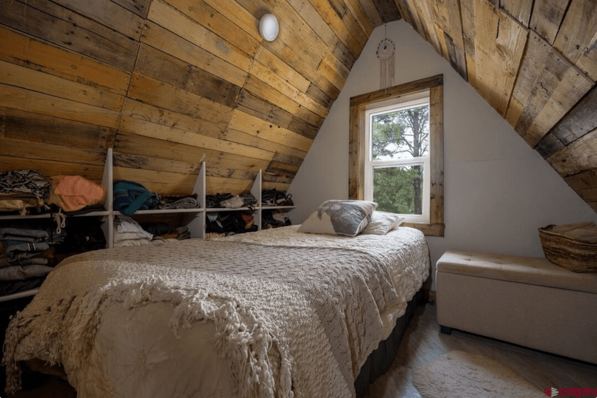 A bedroom on the second level of 201 Pineview Road has vaulted ceilings.