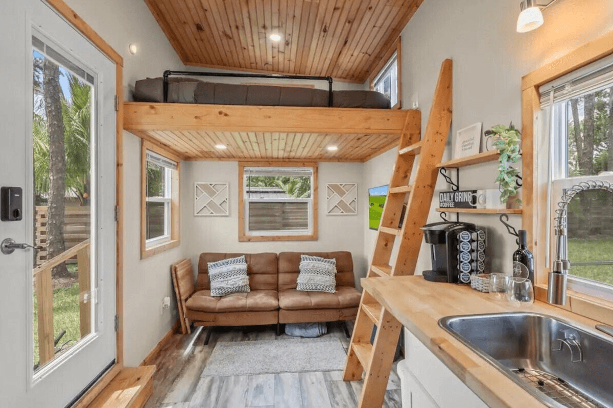 The living area in 4871 127th Trail North has a small sofa under the bedroom loft.