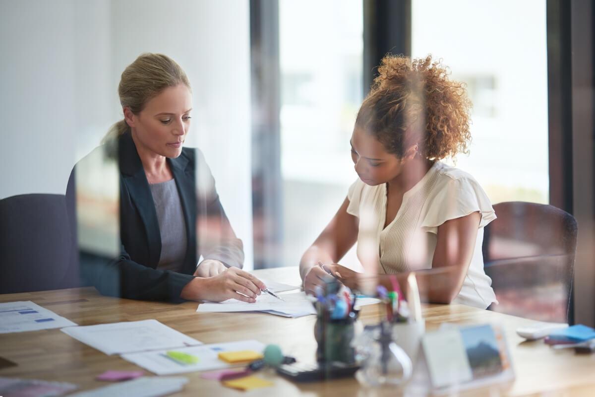 A financial advisor guides a young woman through a financial plan.