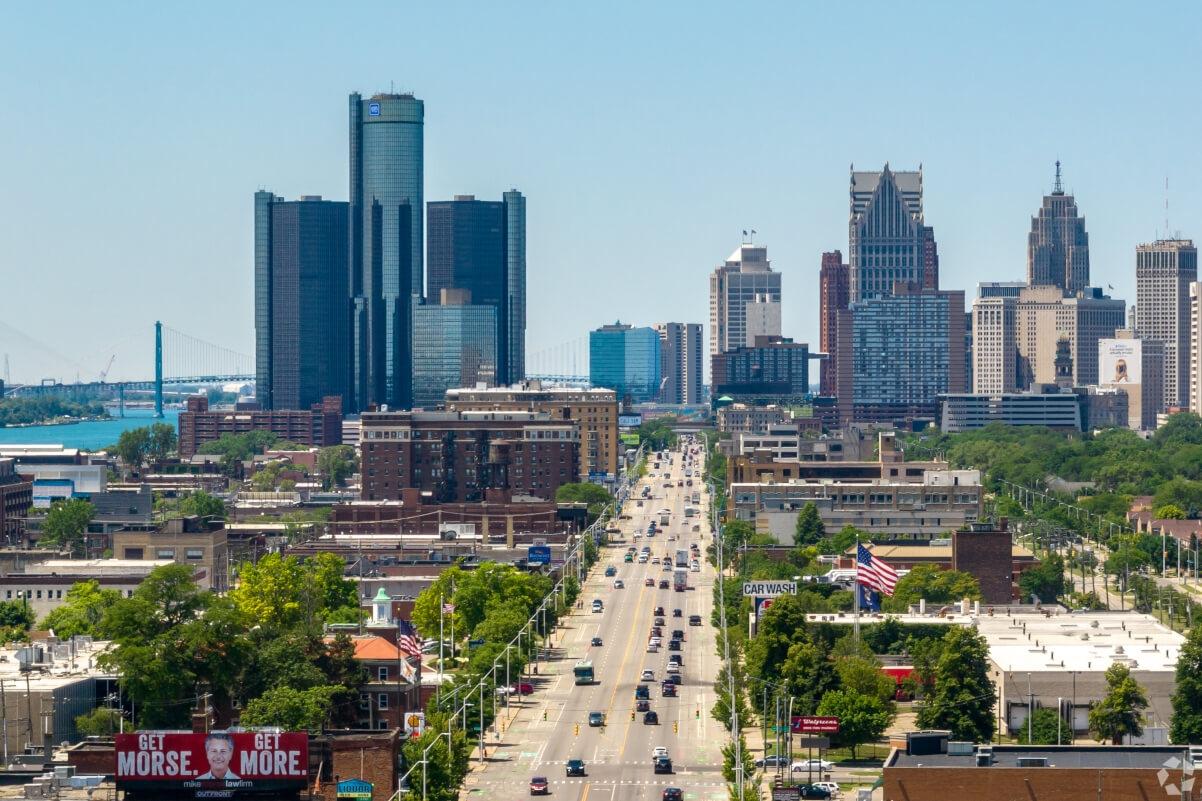 Looking down a busy street at Detroit's skyline.