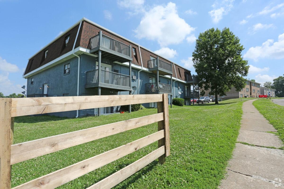 The Park Vista apartment complex is surrounded by bright green fields and lush trees.