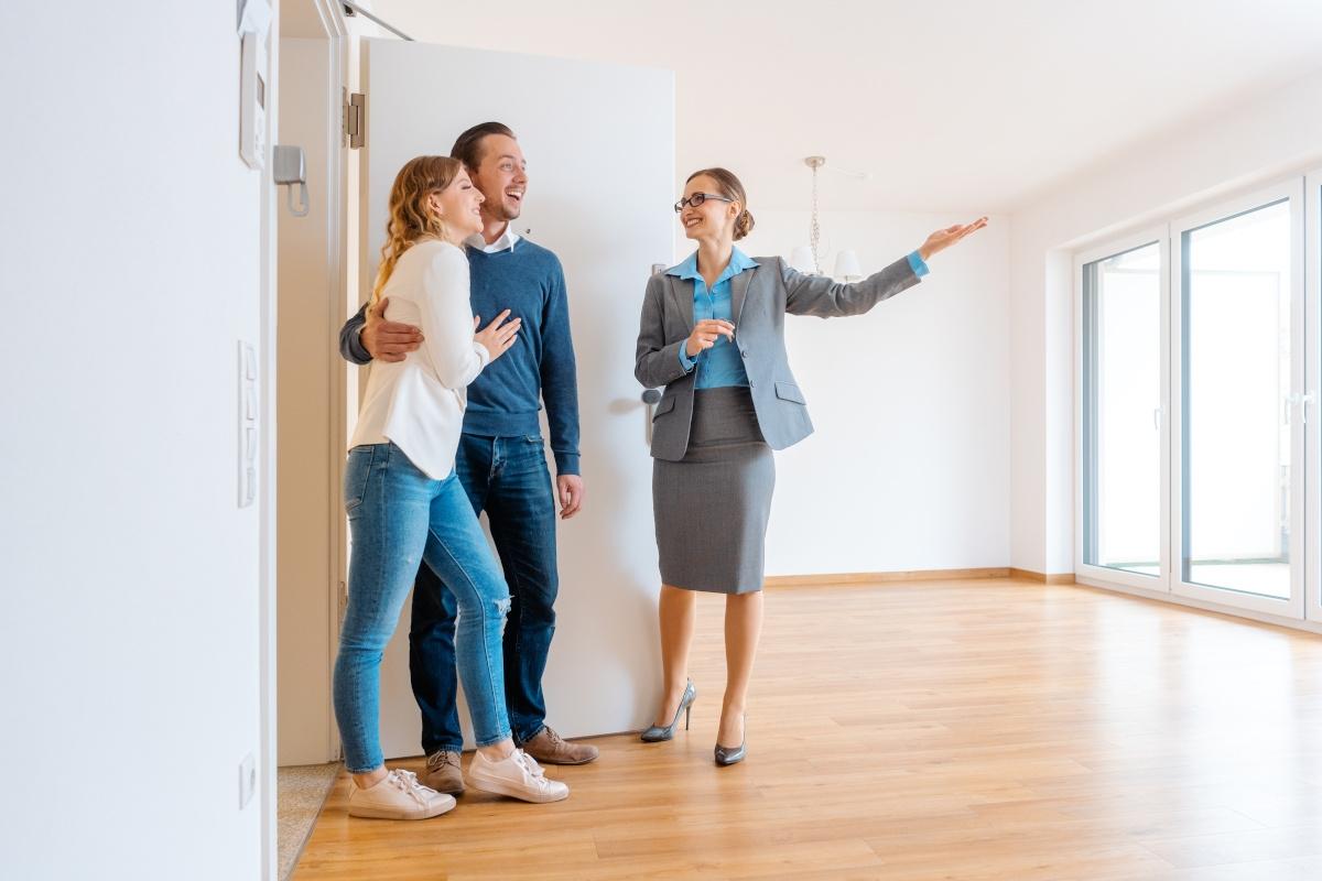 Three people touring an empty apartment