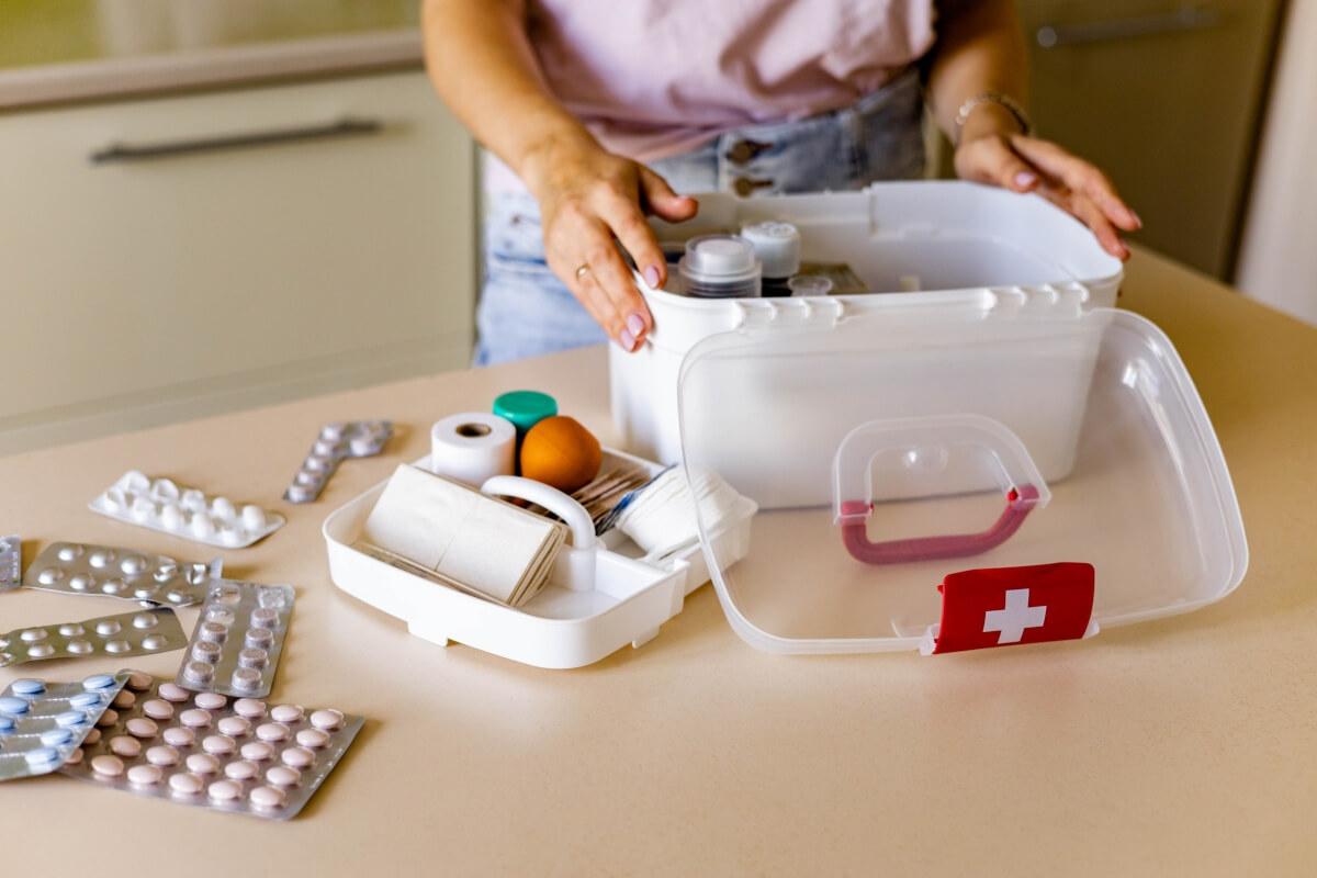 A woman looks into an open first aid kit.