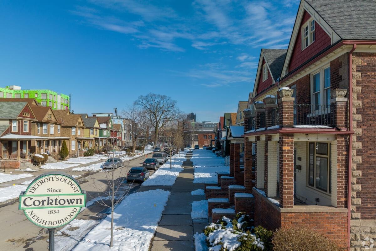 A sign that reads “Corktown: Detroit’s Oldest Neighborhood” stands in front of a row of historic homes.