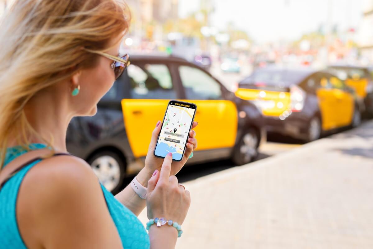 A woman requests a ride on a ridesharing app.