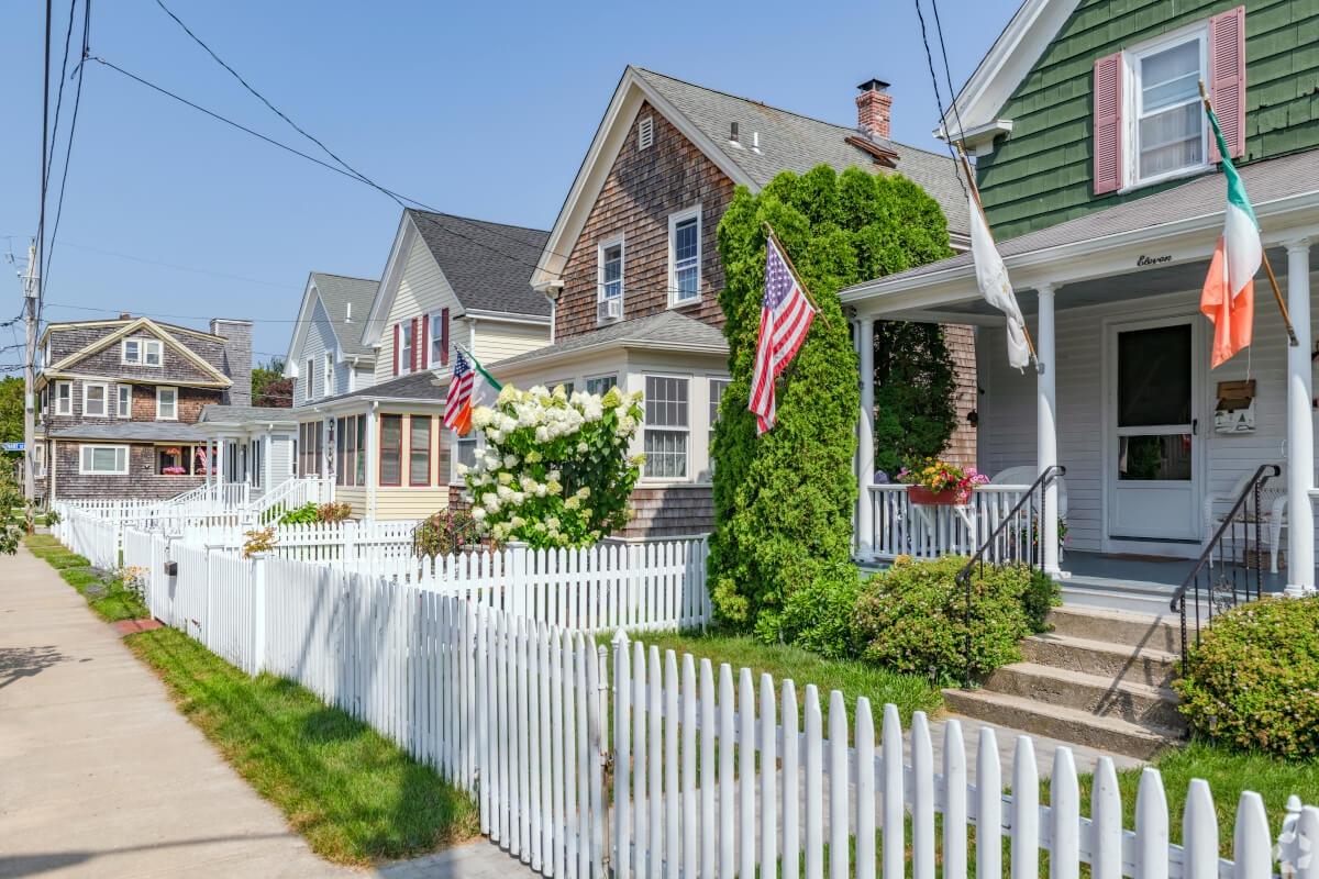 A row of Craftsman-style homes are lined with white picket fences in Newport.