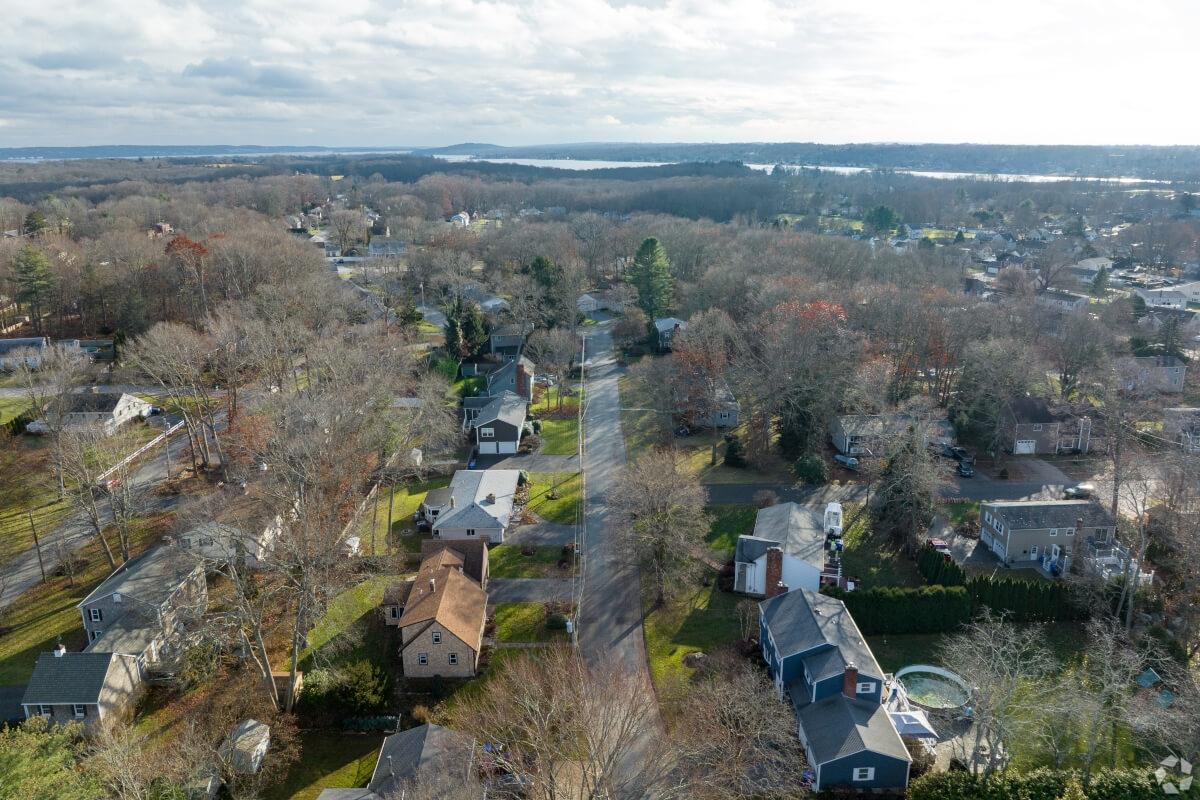 An aerial view of Warren, RI, shows single-family homes and tree-lined streets.