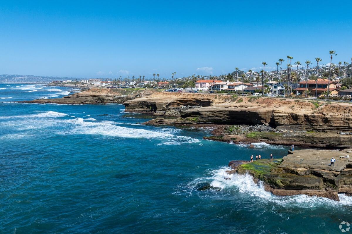 Over the water shot of the cliffs in Sunset Cliffs and the houses on top.