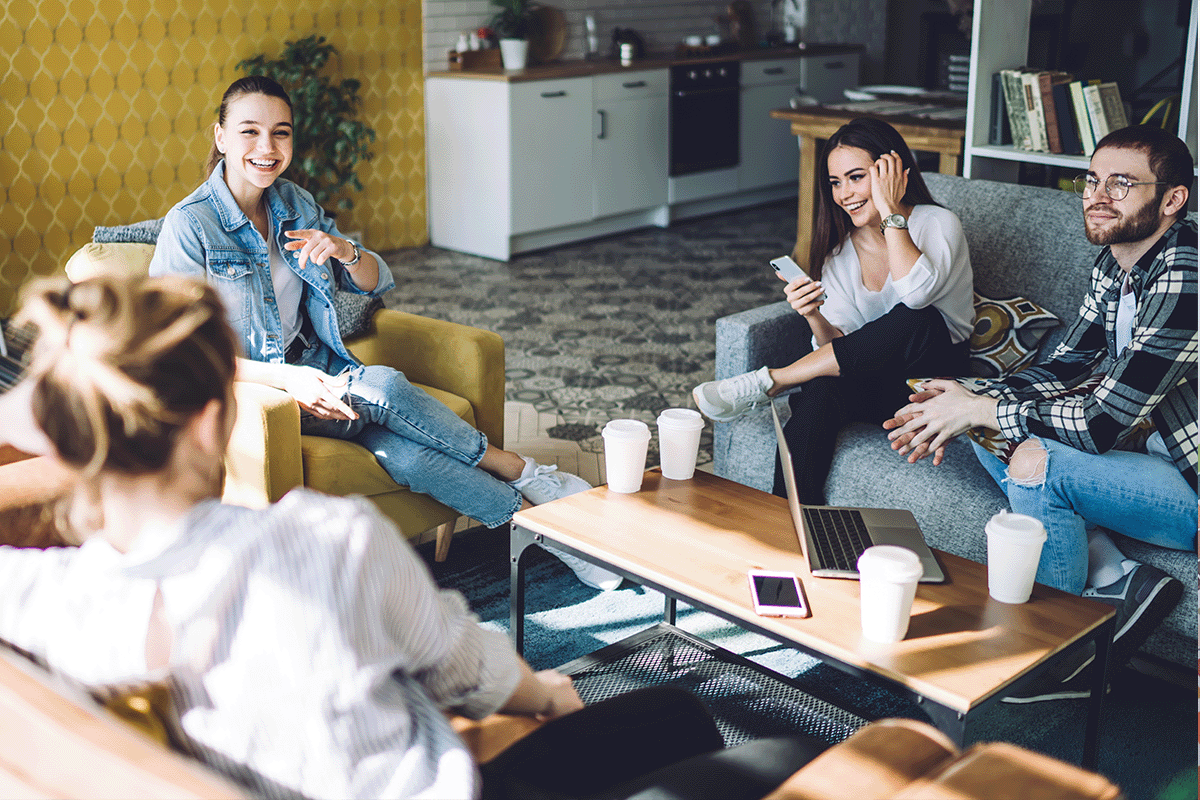 four people sitting in an apartment lounge together