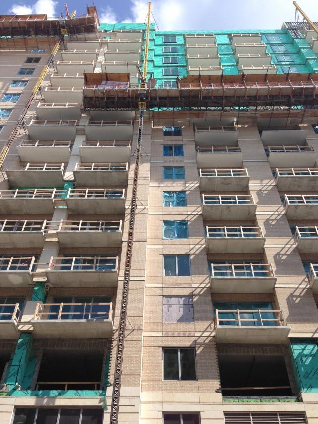 Close-up of a tall apartment building from the ground looking up.