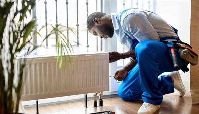 Person repairing a radiator in an apartment. 