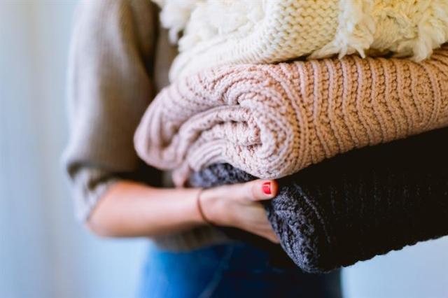 Holding a stack of blankets