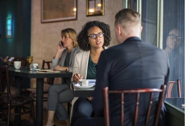 Two people having a discussion in a cafe.