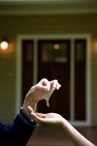 A key is placed in the palm of another person