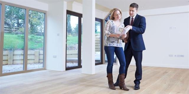 Two people reviewing a lease in an empty apartment.