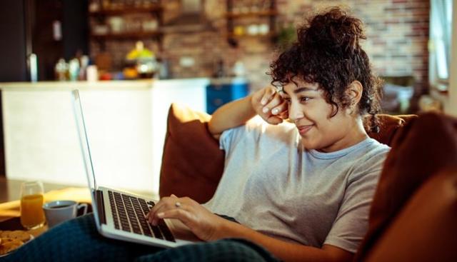 A woman pondering over a laptop