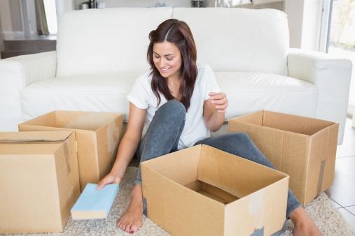 Woman surrounded by moving boxes.