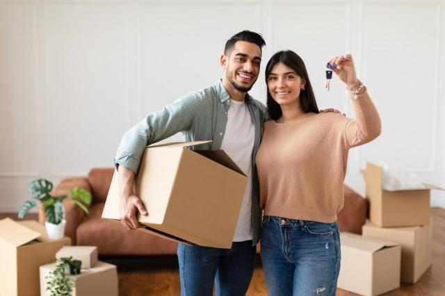 A man holding a box and a woman holding a key. 