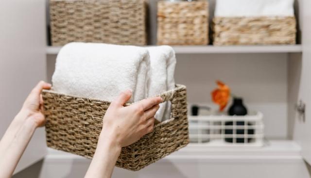 Renter organizing their bathroom cupboard with baskets.