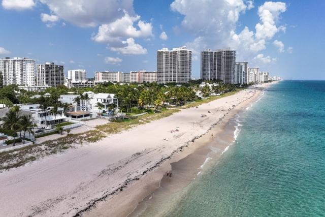 An aerial view of Fort Lauderdale Beach shows miles of white sand with high rise condos in the distance.