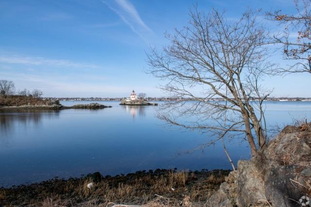 A distant shot shows the Pomham Rocks Lighthouse on the Providence River in the Riverside neighborhood.