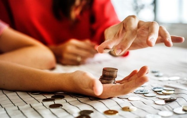 Two people stacking coins