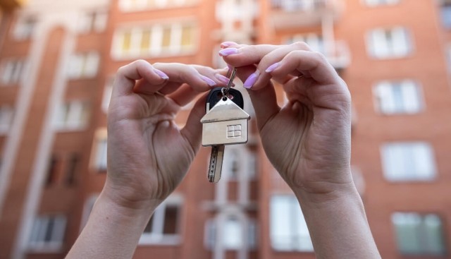 Hands holding keys to apartment.