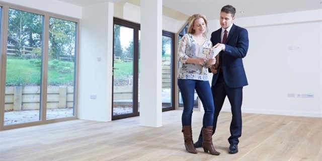 Two people reviewing a lease in an empty apartment.