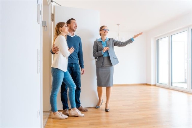 Property owner shows off apartment to a couple. 