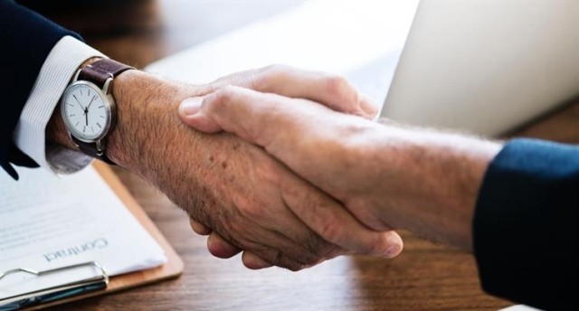 Shaking hands over desk