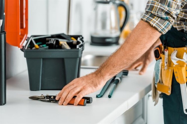 Open toolbox and a worker reaching for a tool