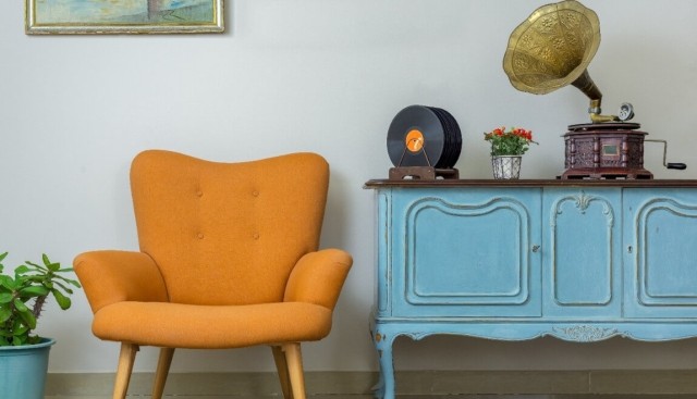 Mid-century modern orange chair next to a rustic blue desk.