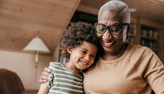 A woman reading with her grandchild.