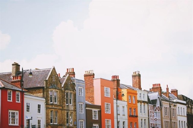 Row of flats in various shades of stucco and stone.