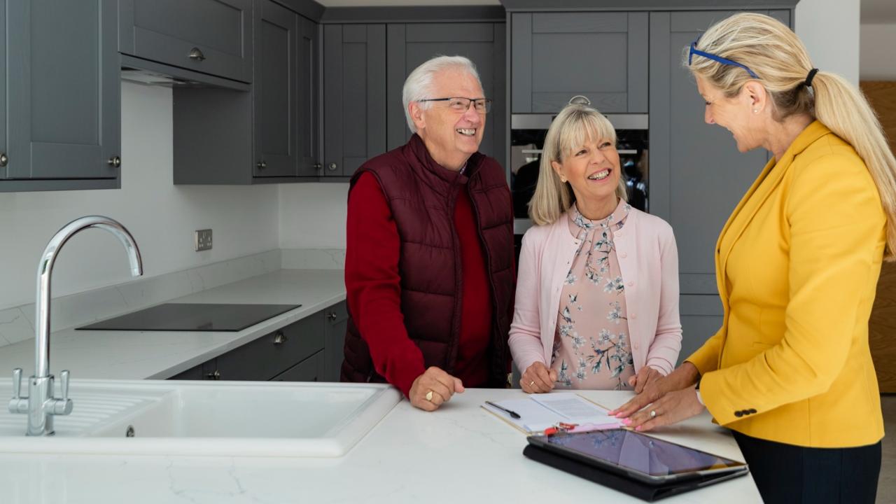 Senior couple tours an apartment with a leasing agent