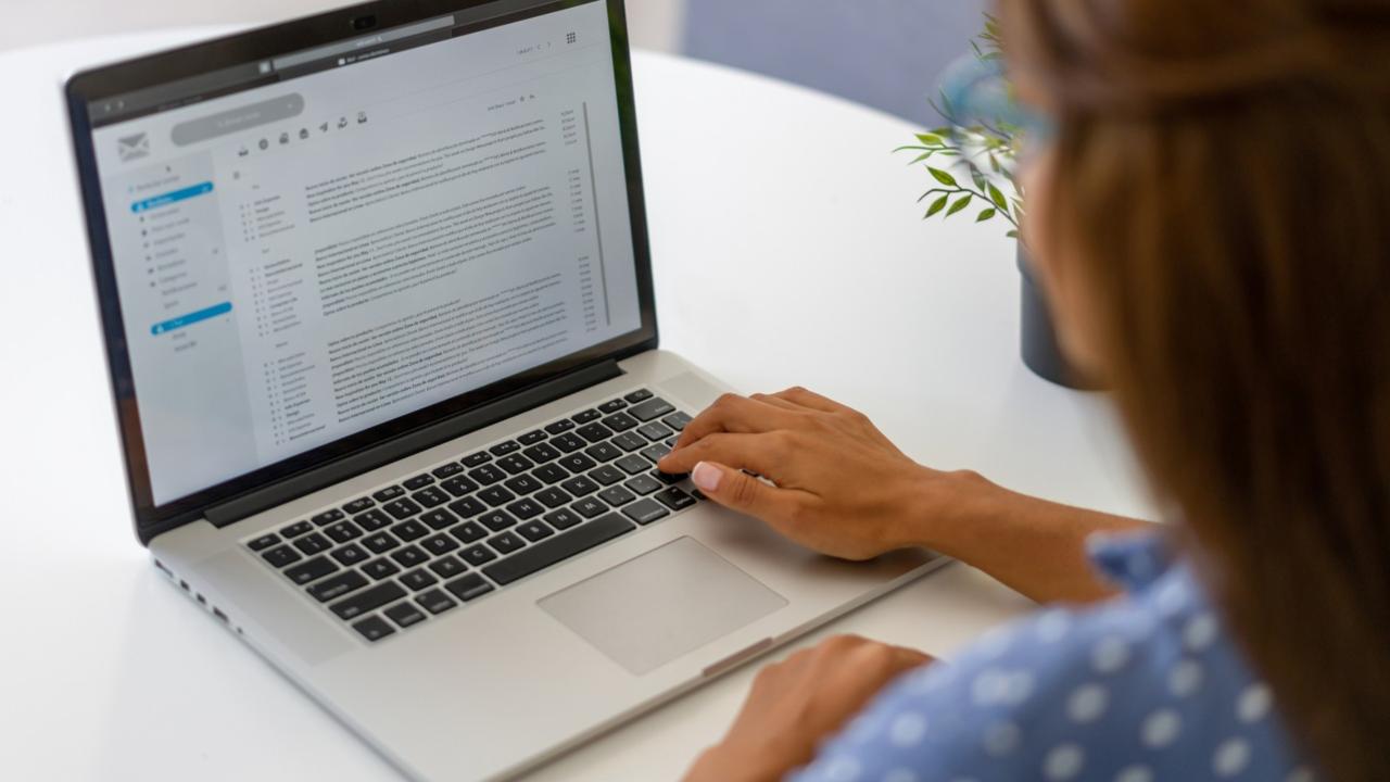 Woman reads email on a laptop