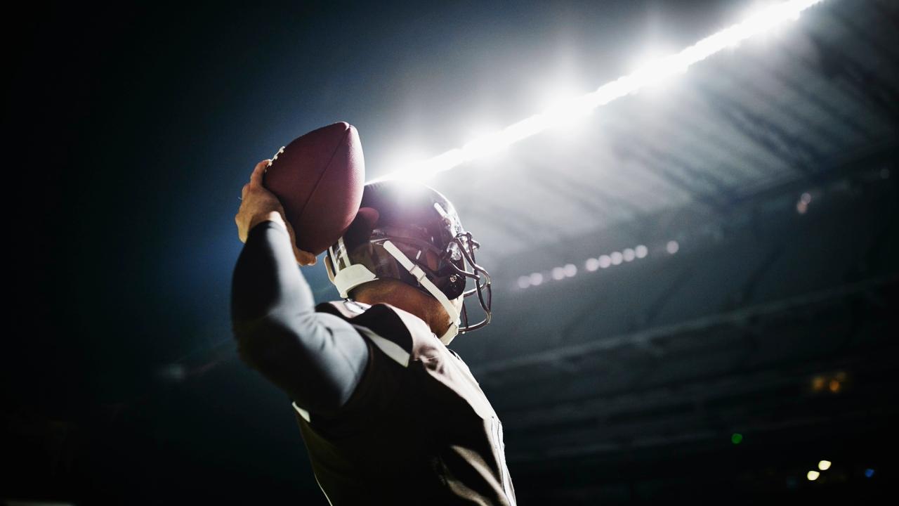 Football player triumphantly holding ball