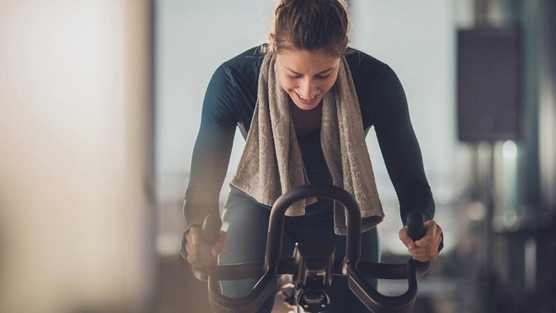 Woman pedals on exercise bike