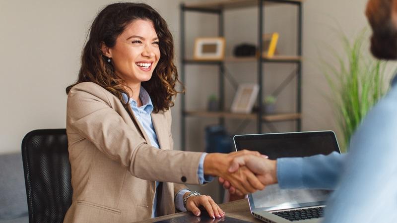 Smiling leasing agent shakes hand with renter