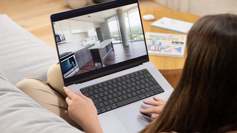 Woman clicks on 3D virtual tour on laptop