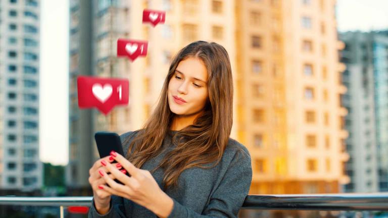 woman in city with heart icons coming from phone