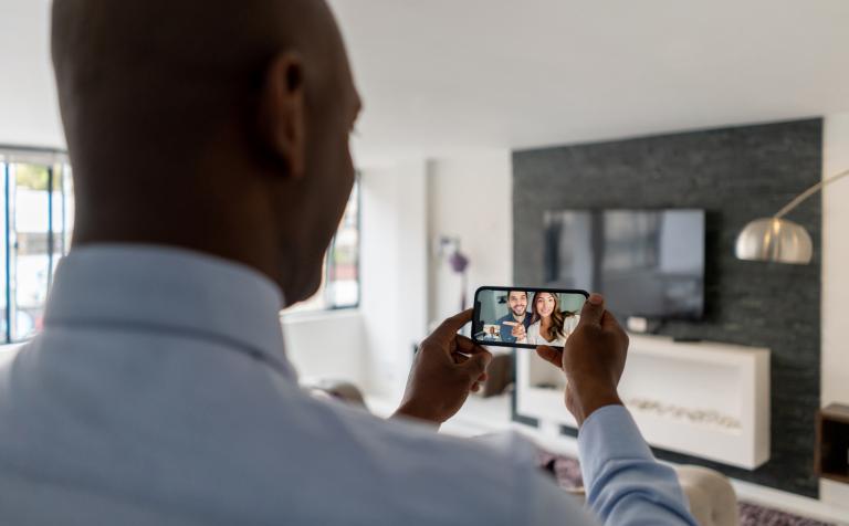 A man using Facetime to talk to a young couple