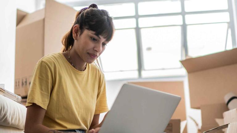 Woman on computer with boxes in background