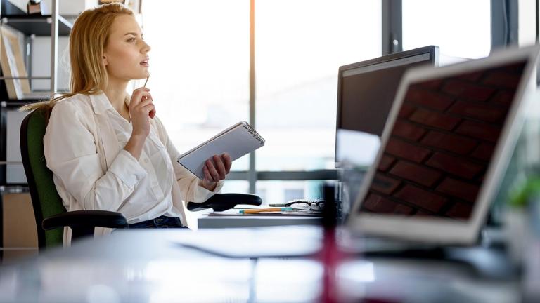 Female employee looks at computer screen